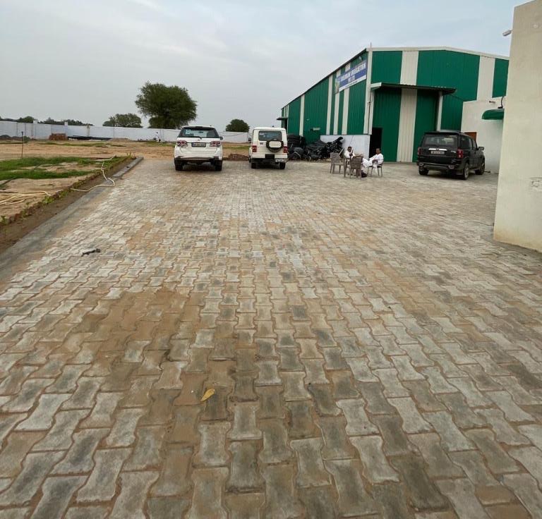 Warehouse front yard with staff and vehicles